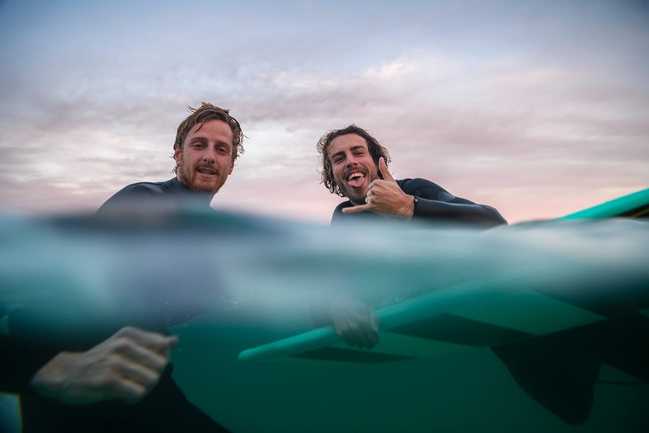 Two guys in the ocean having fun.